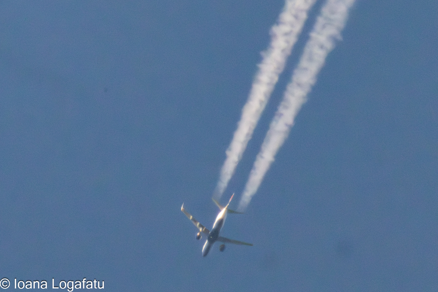 Airplane soaring through a clear blue sky above